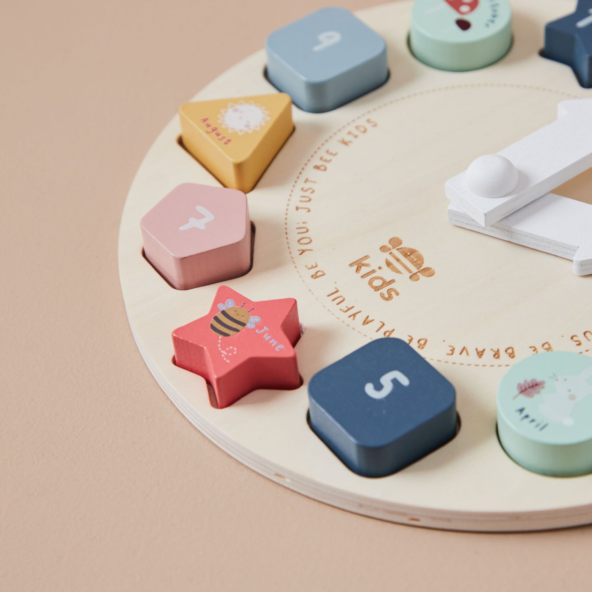 Colourful wooden shape sorting clock toy on a wooden surface
