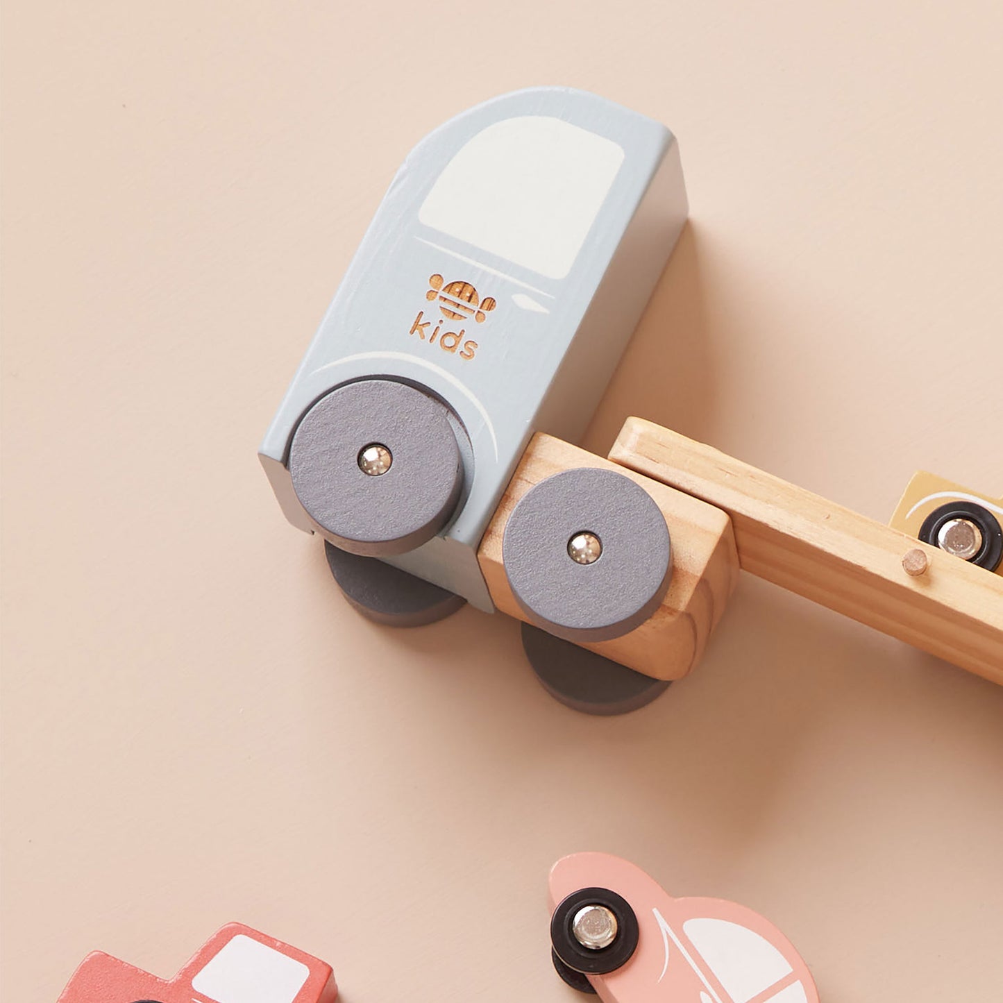 Wooden toy car transporter on a beige background