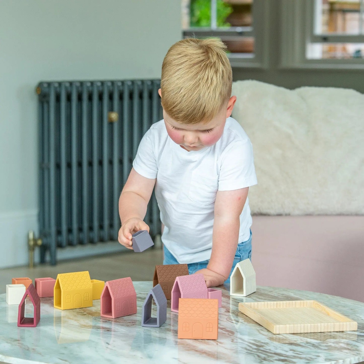 Child playing with silicone blocks on a marble table