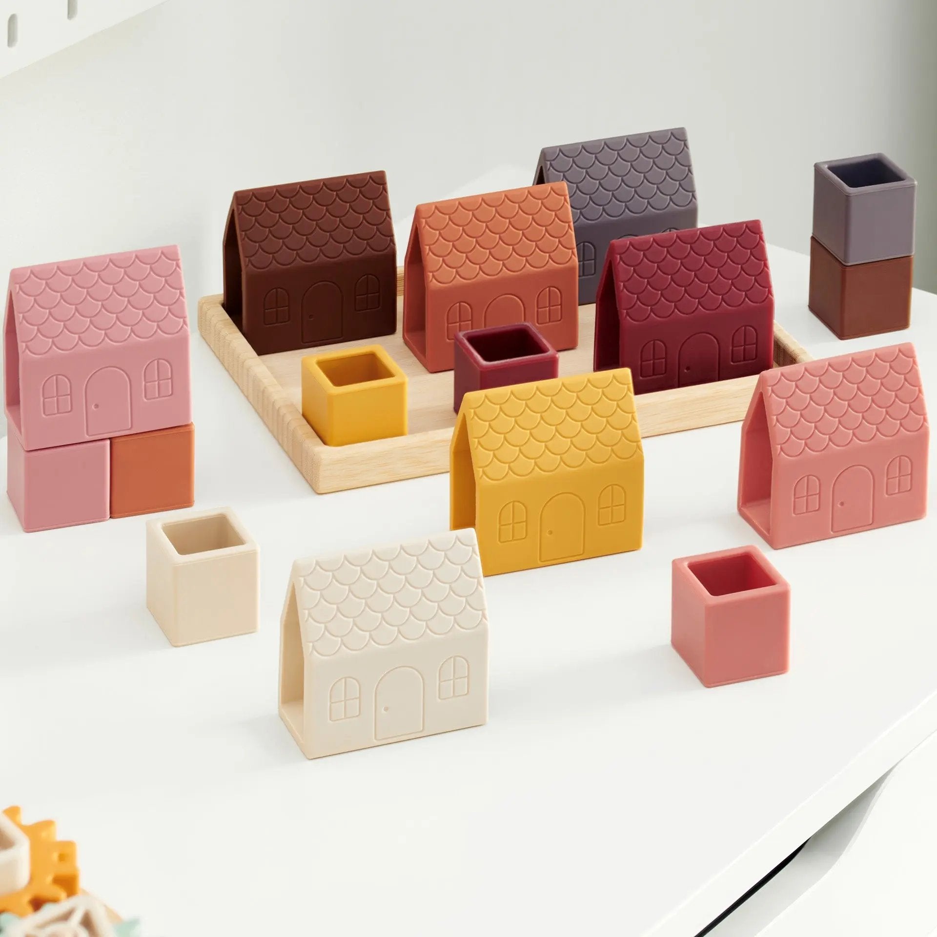 Set of colourful ceramic house-shaped blocks on a white surface