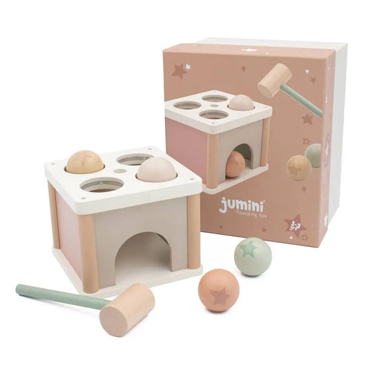 Wooden toy with shape-sorting holes and balls, alongside packaging labeled 'jumini'.