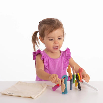 Child playing with colourful wooden toys on a white surface
