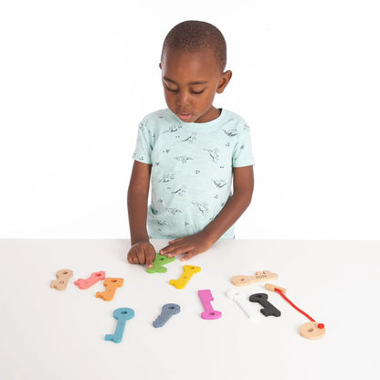 Child playing with colourful wooden keys on a white surface