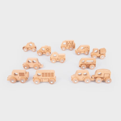 Set of small wooden toy cars on a light grey background