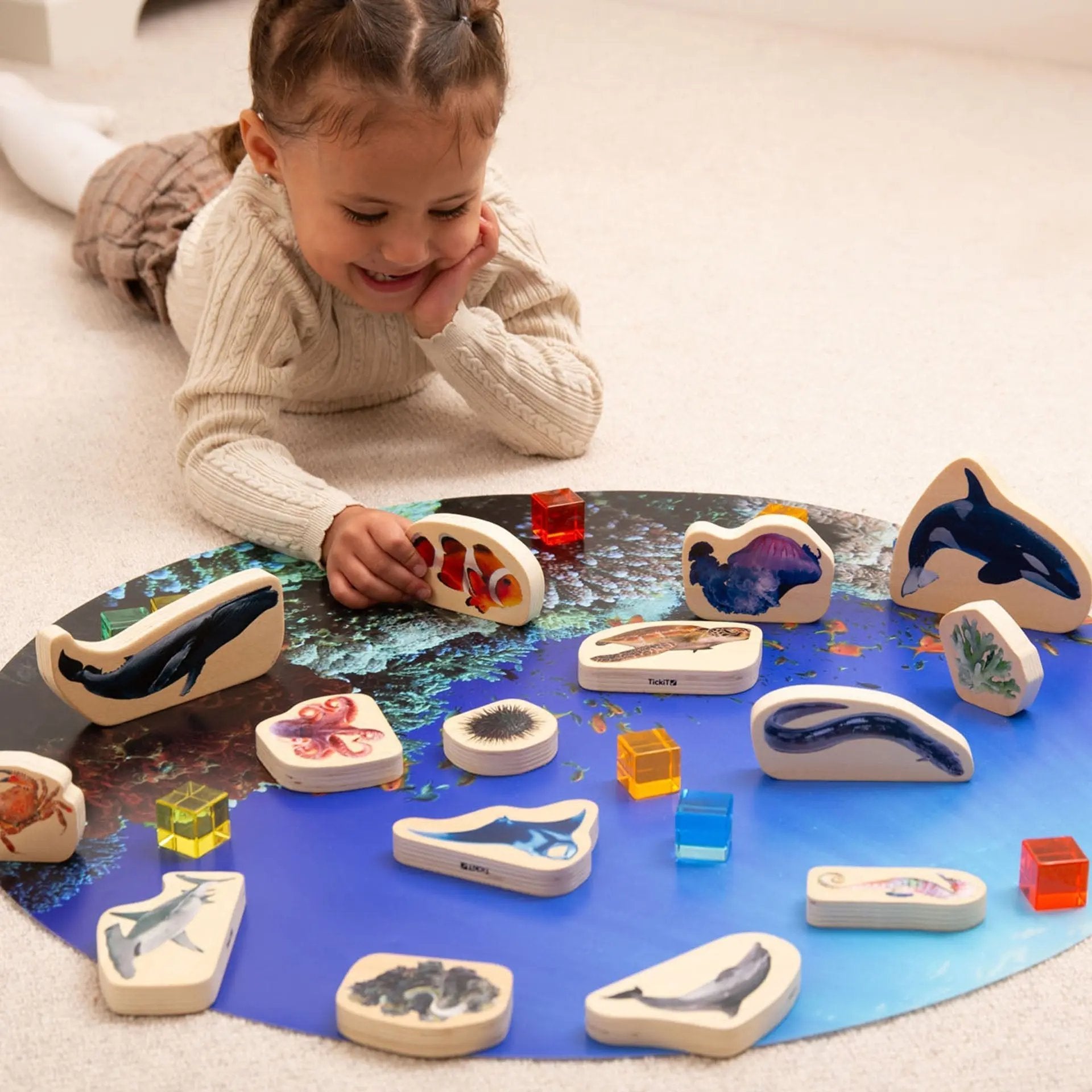 Child playing with educational animal figurines on a mat