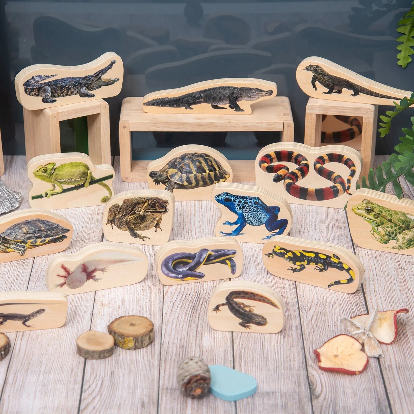 Set of wooden animal figures on a wooden surface with a blurred background