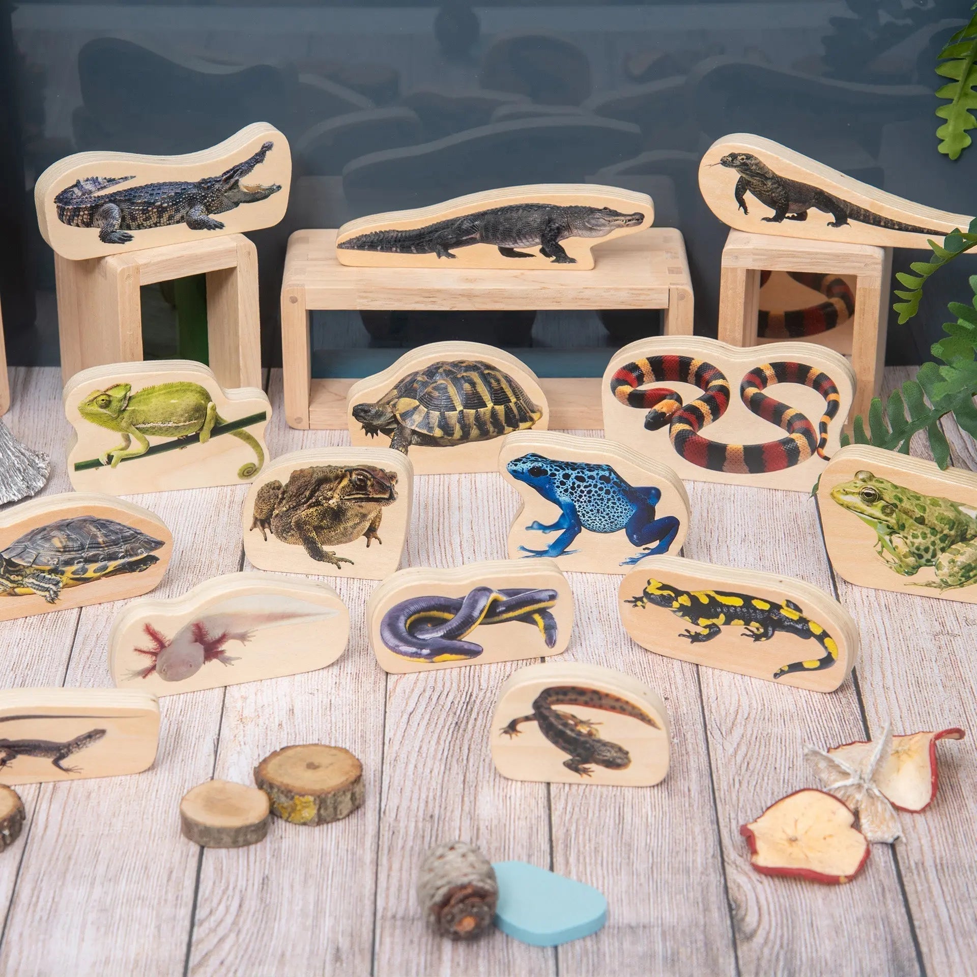 Set of wooden animal figures on a wooden surface with a blurred background