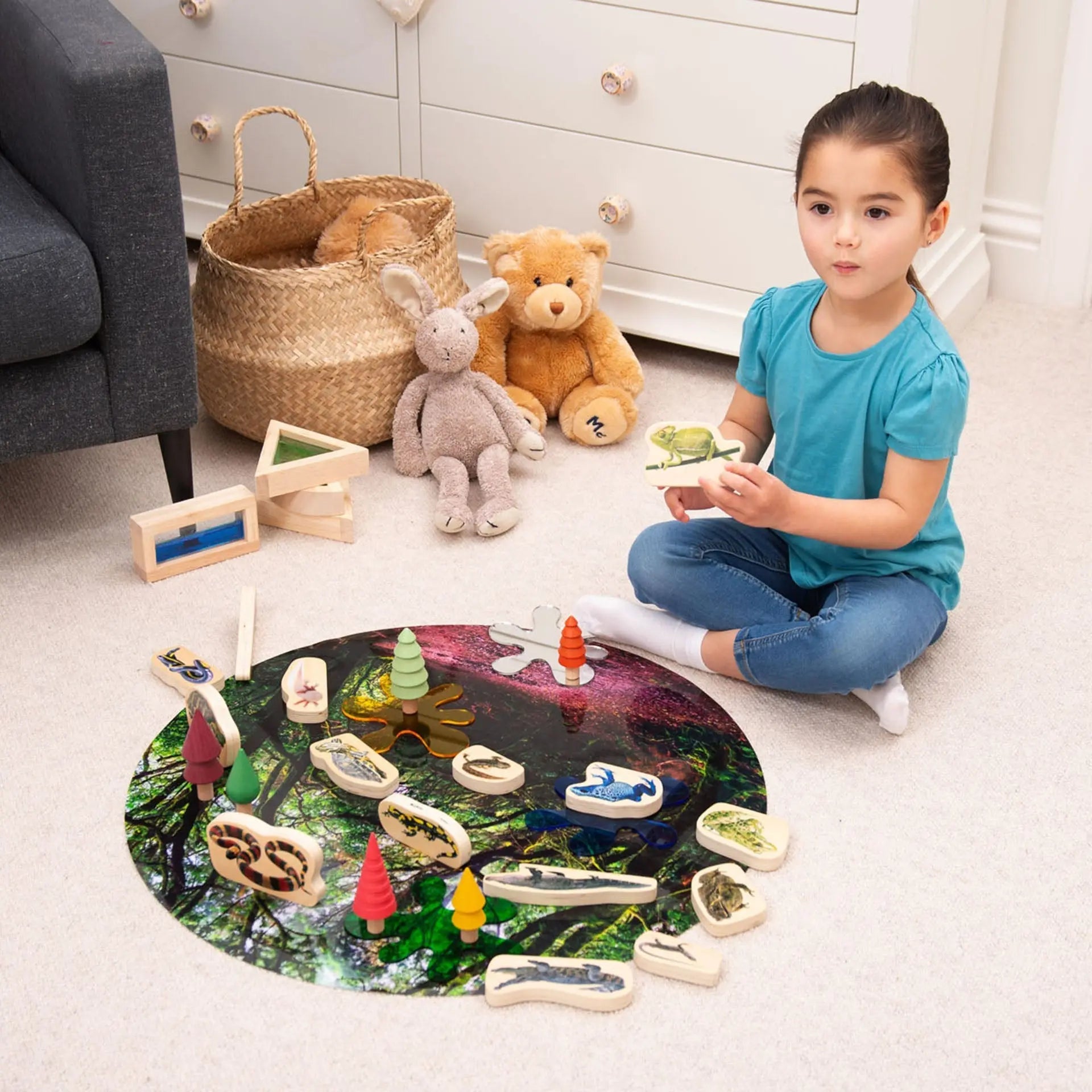 Child playing with a toy set on the floor in a room with toys and furniture.