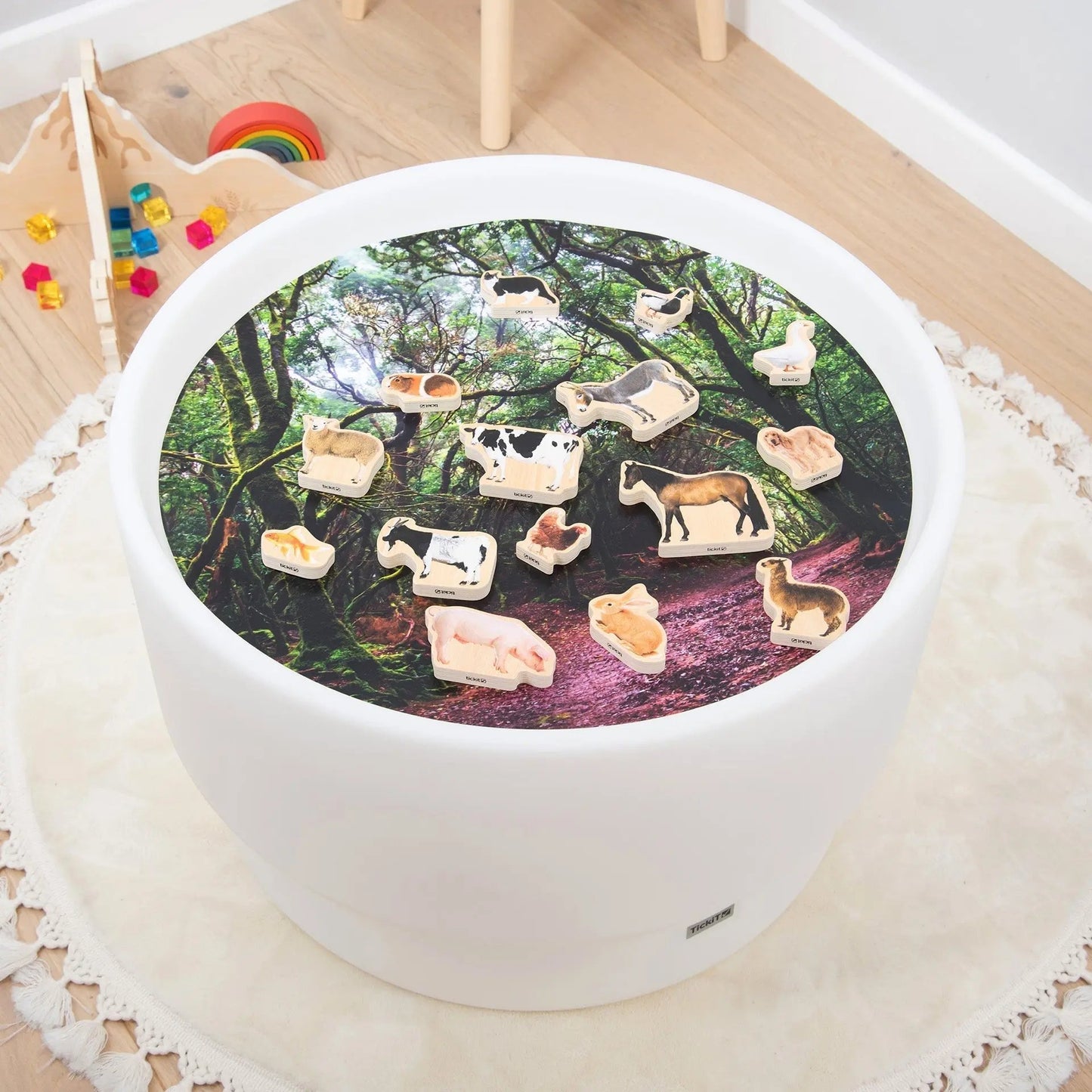 Round white table with animal-themed decor on a wooden floor.