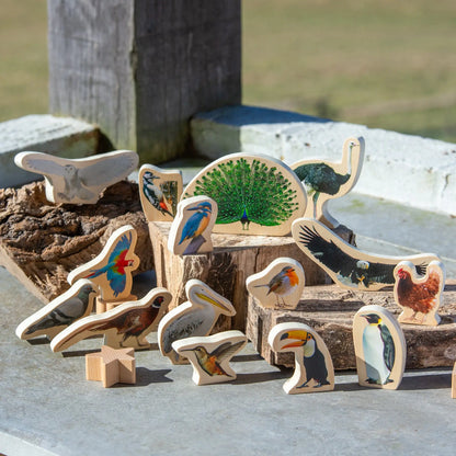 Collection of wooden animal figurines on a stone surface with a natural background.