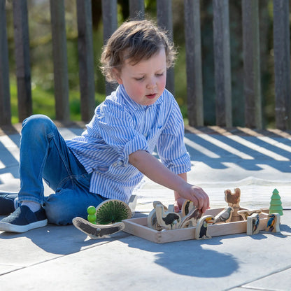 Child playing with wooden toys outdoors on a sunny day