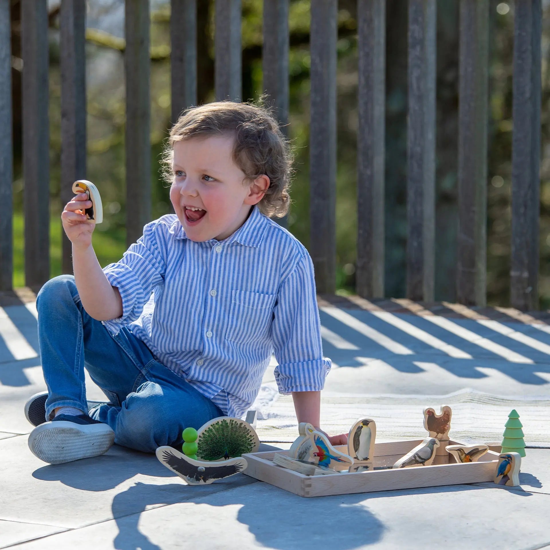 Child playing with wooden toys on a deck