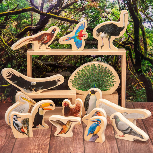 Set of wooden bird figurines on a wooden surface with a natural background