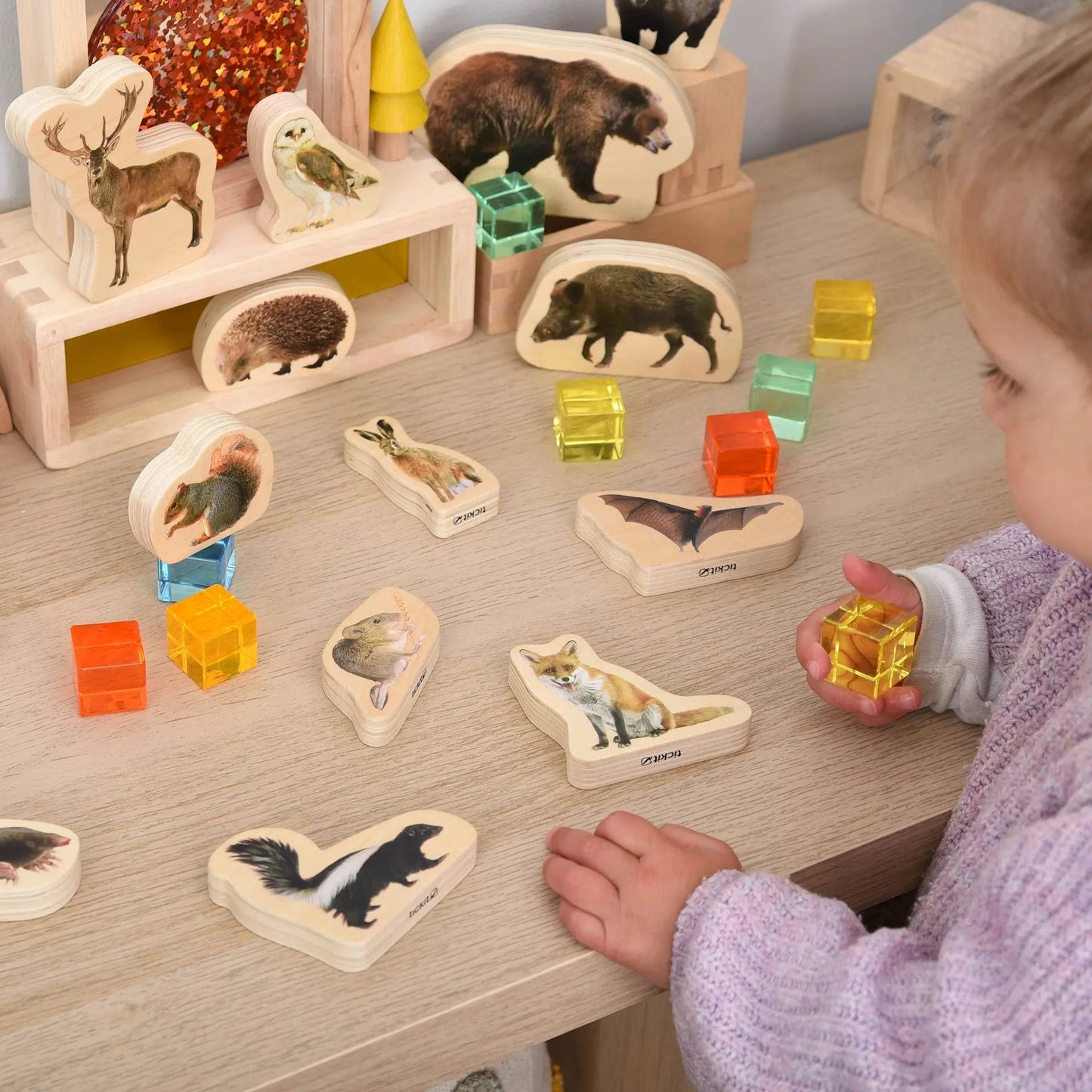 Child playing with a wooden animal puzzle on a table