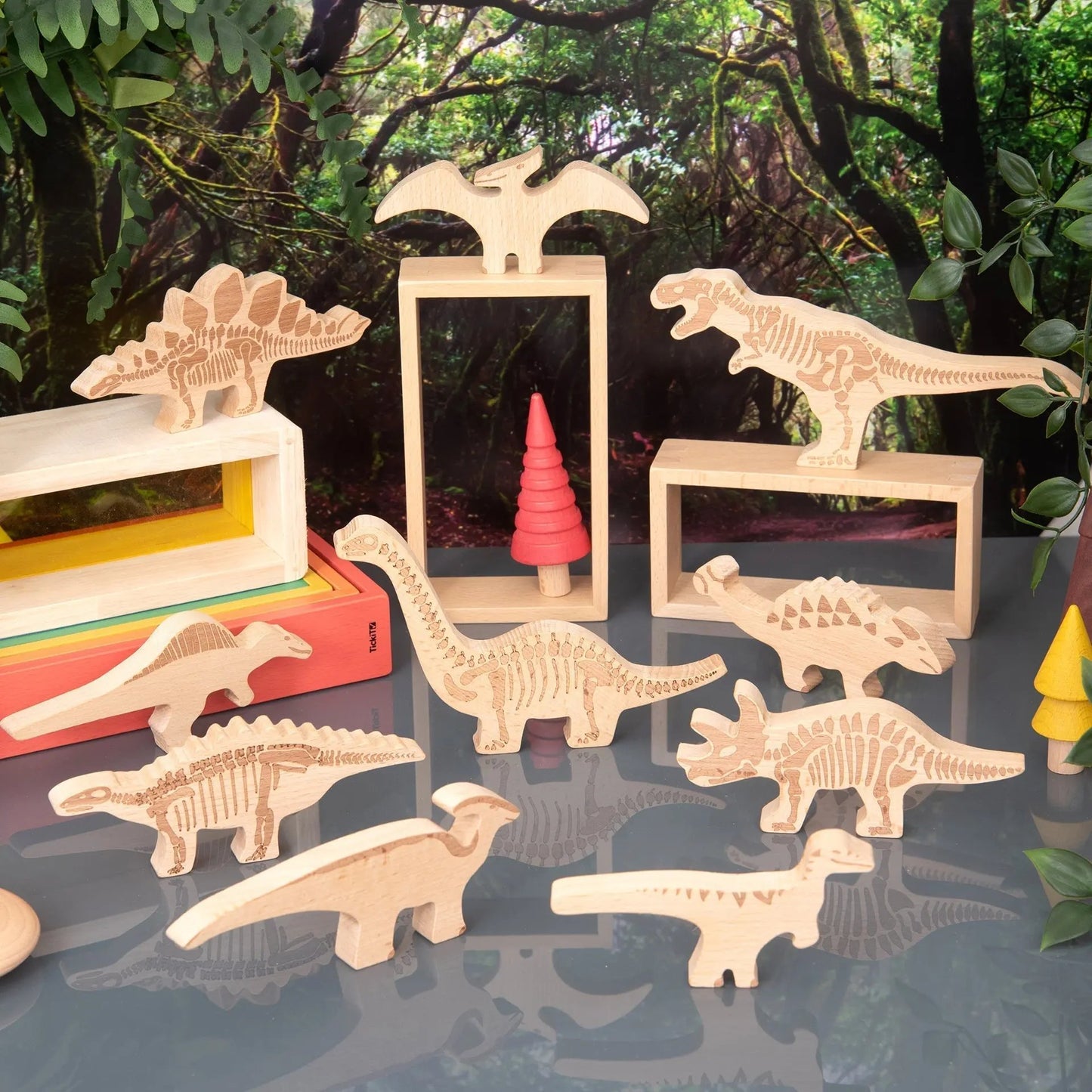 Wooden dinosaur toys on a reflective surface with a jungle-themed background