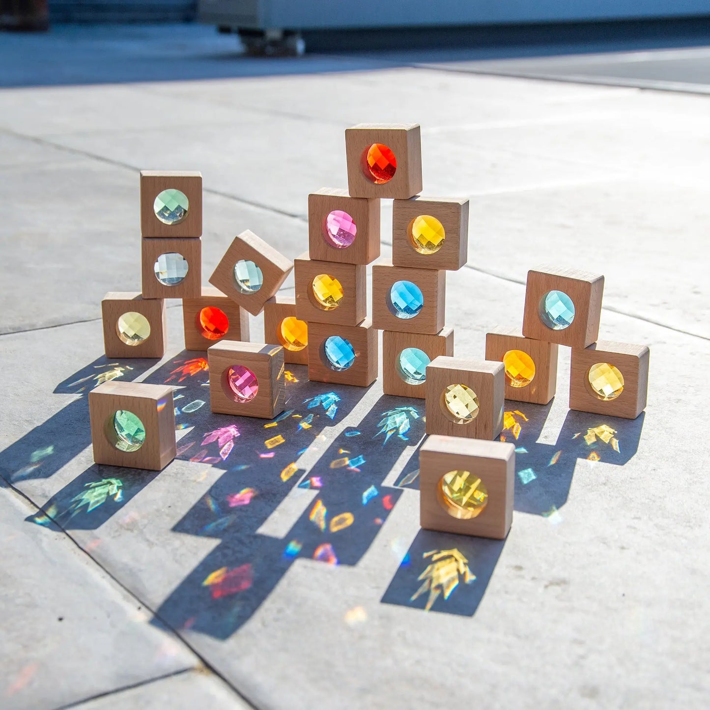 Wooden blocks with gemstone reflections on a concrete surface