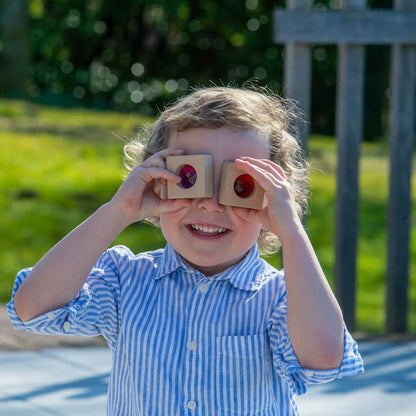 Child playing with wooden blocks outdoors