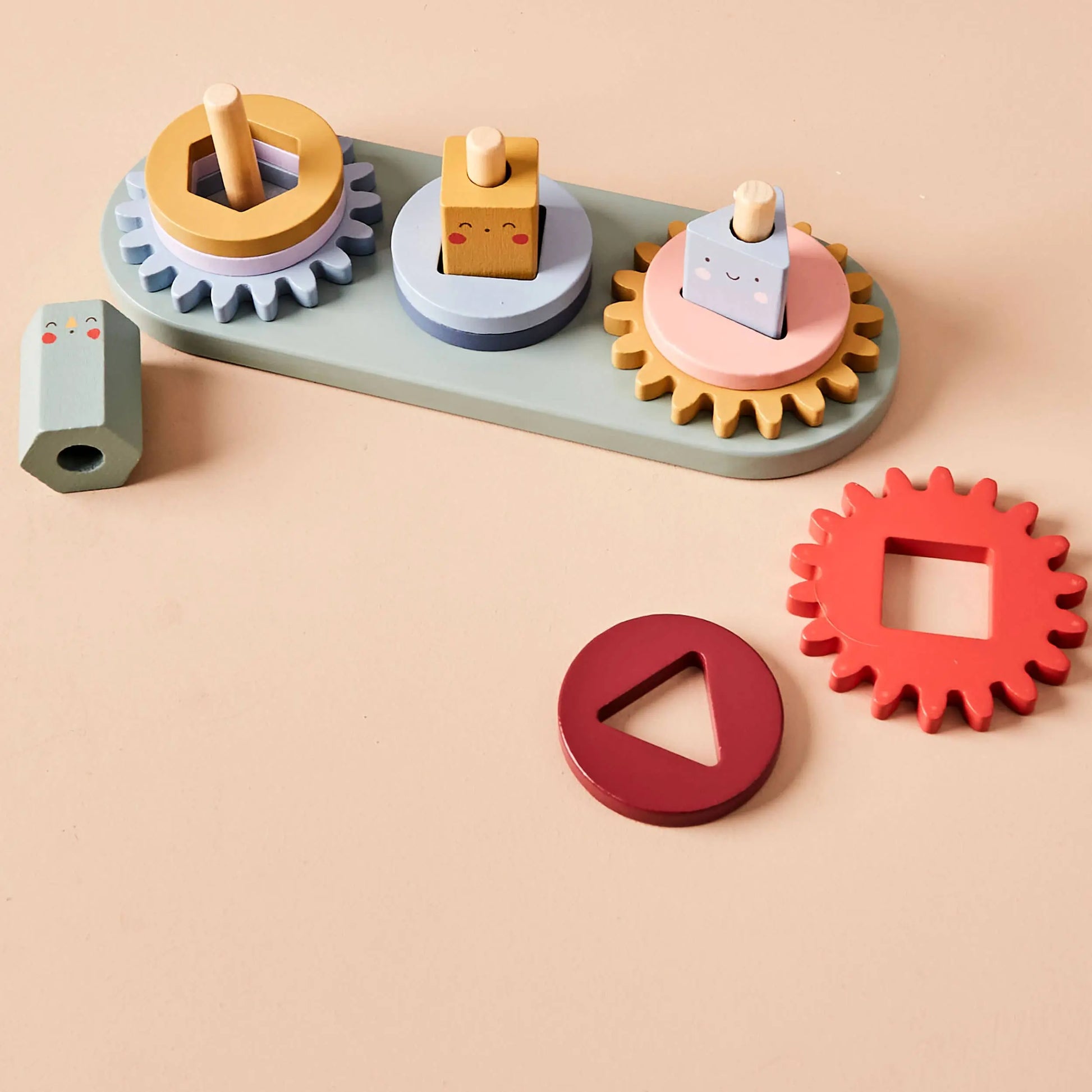 Colourful toy gears on a beige background