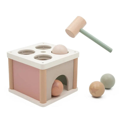 Wooden toy set with a box, balls, and a hammer on a white background