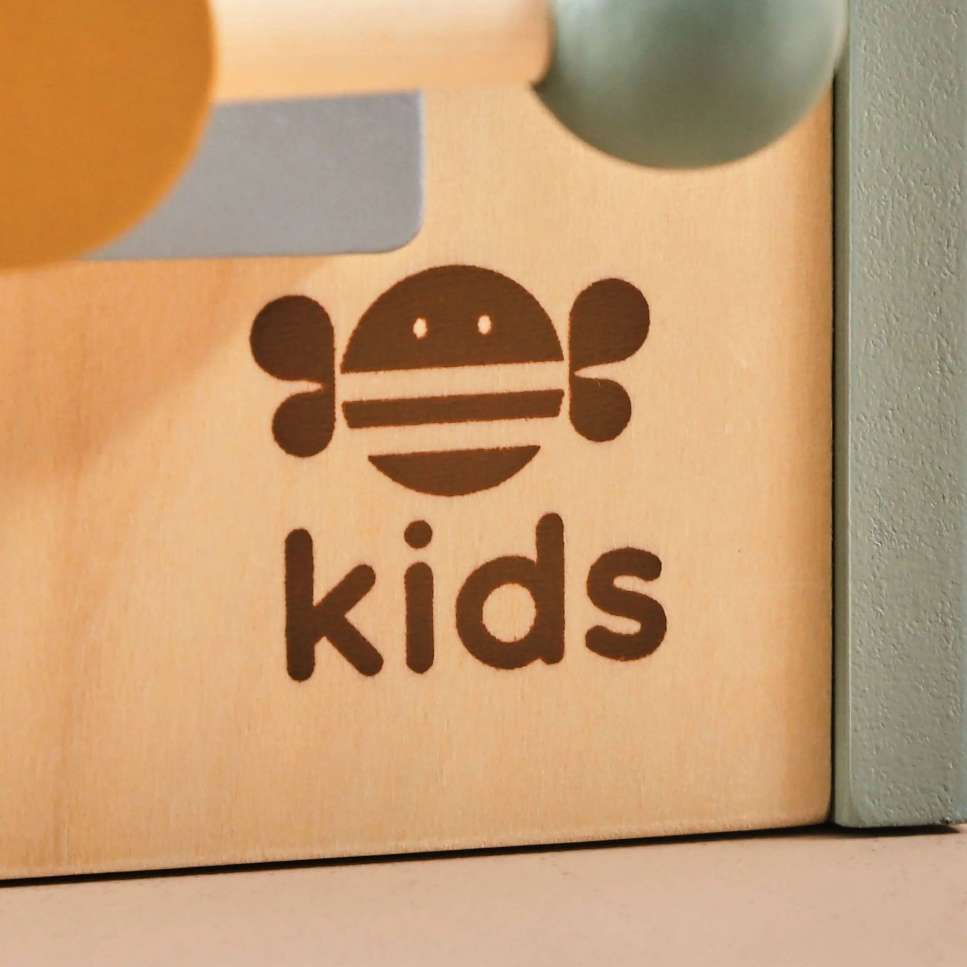 Wooden toy box with 'just bee kids' logo on a neutral background