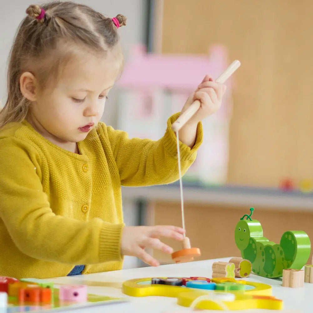 Child playing with a wooden toy in a playroom setting