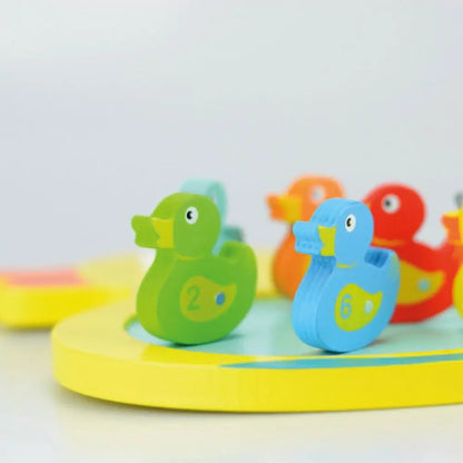 Colourful duck-shaped figures on a yellow base with a light grey background
