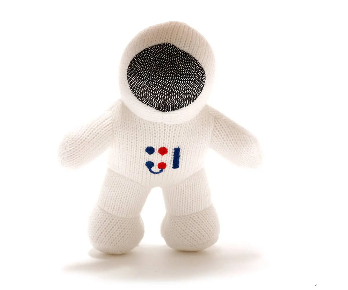 A knitted astronaut plush toy in white with a black mesh visor and a small red, white, and blue chest emblem, photographed on a clean white background.