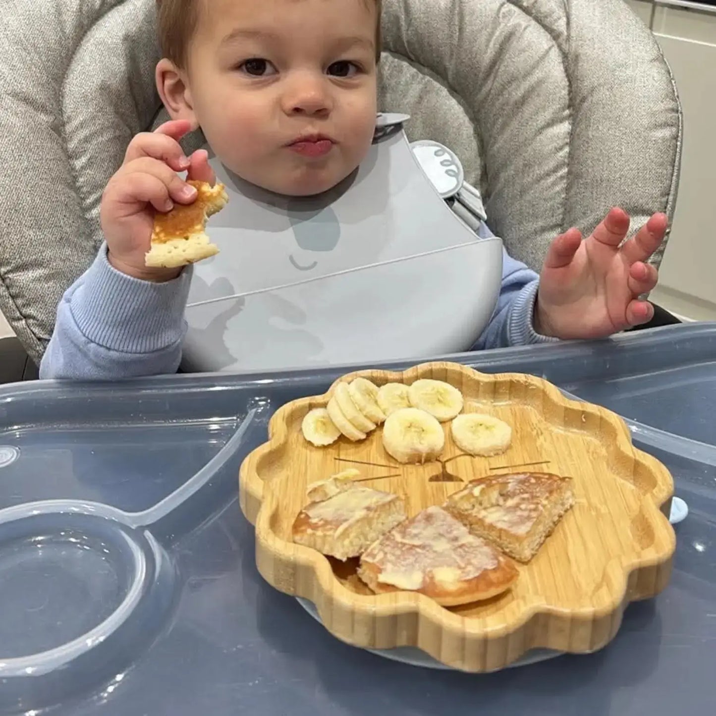 Toddler eating from a lion shaped bamboo suction plate