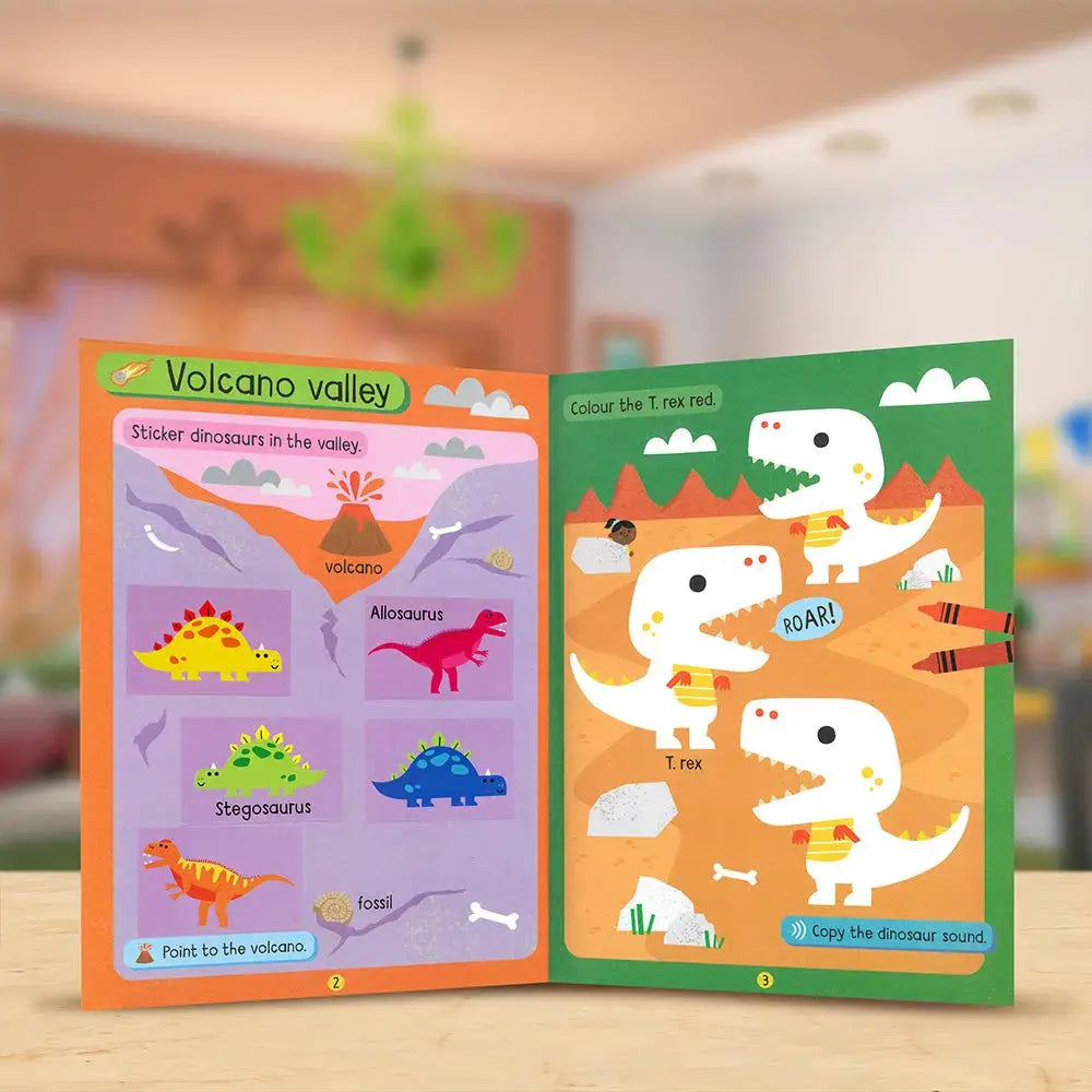 Children's activity book with dinosaur illustrations on a wooden surface.
