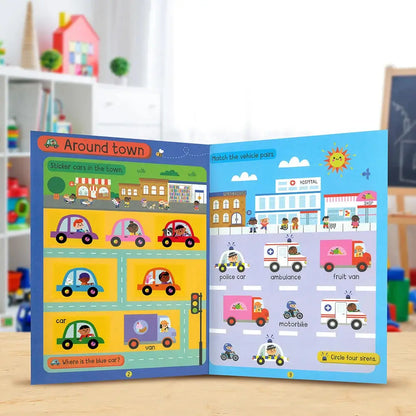 An open children's educational sticker-and-match activity book titled 'Around town' showing colourful cartoon vehicles and road scenes on both pages, photographed on a tabletop with a blurred playroom background.