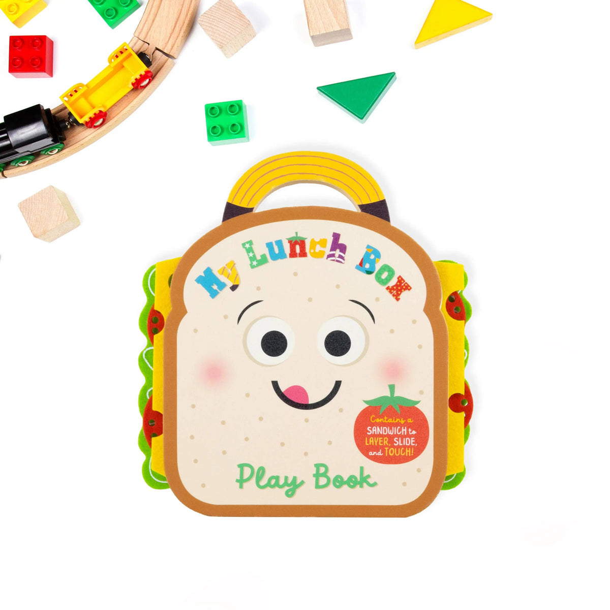Toy lunch box with a face design surrounded by building blocks on a white background