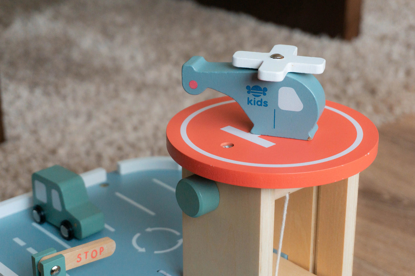 Wooden toy helicopter on a circular platform with a road track below.