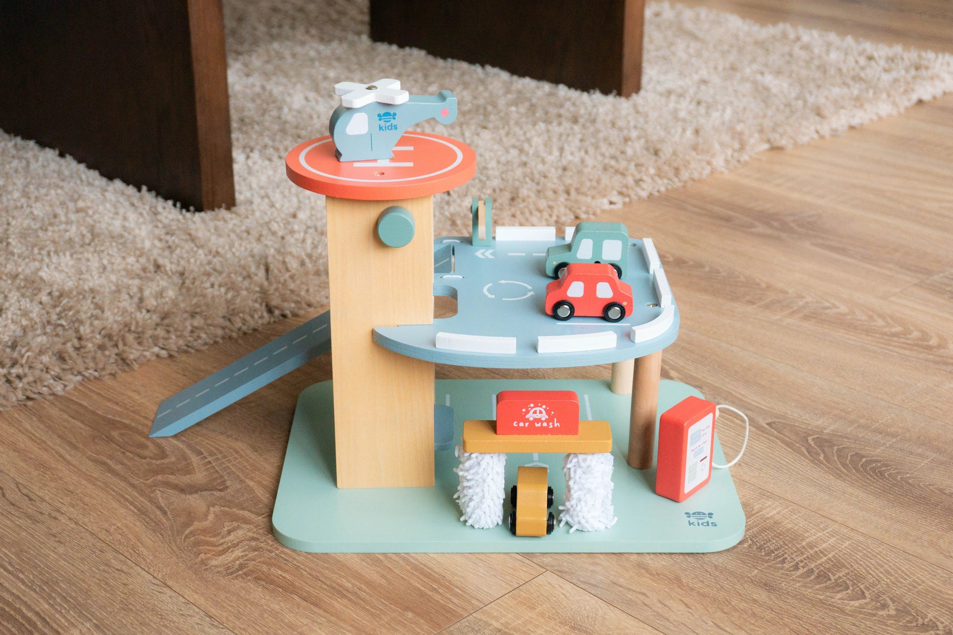 Toy garage set with cars on a wooden floor