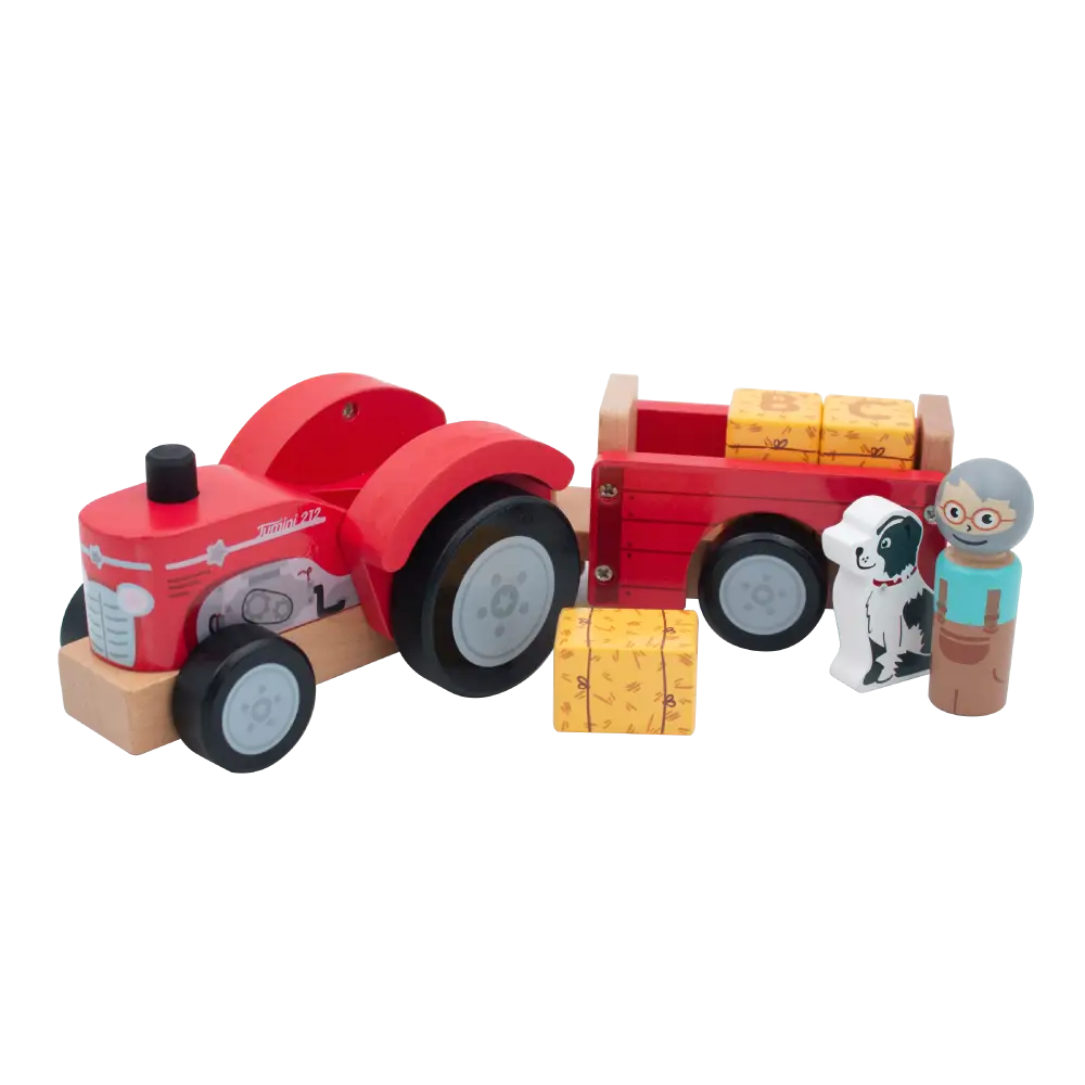 A wooden toy farm scene with a red tractor pulling a red trailer loaded with yellow stacked blocks, plus two small farmer figures and a small dog figure on a white background.