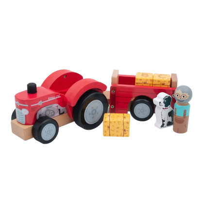 A wooden toy farm scene with a red tractor pulling a red trailer loaded with yellow stacked blocks, plus two small farmer figures and a small dog figure on a white background.