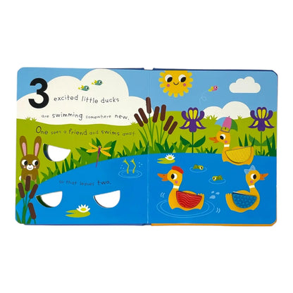A colourful children's board book with illustrated duck scenes and interactive cutout holes, photographed flat against a plain white background.