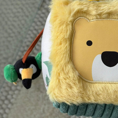 Plush lion toy with a penguin attached on a textured surface