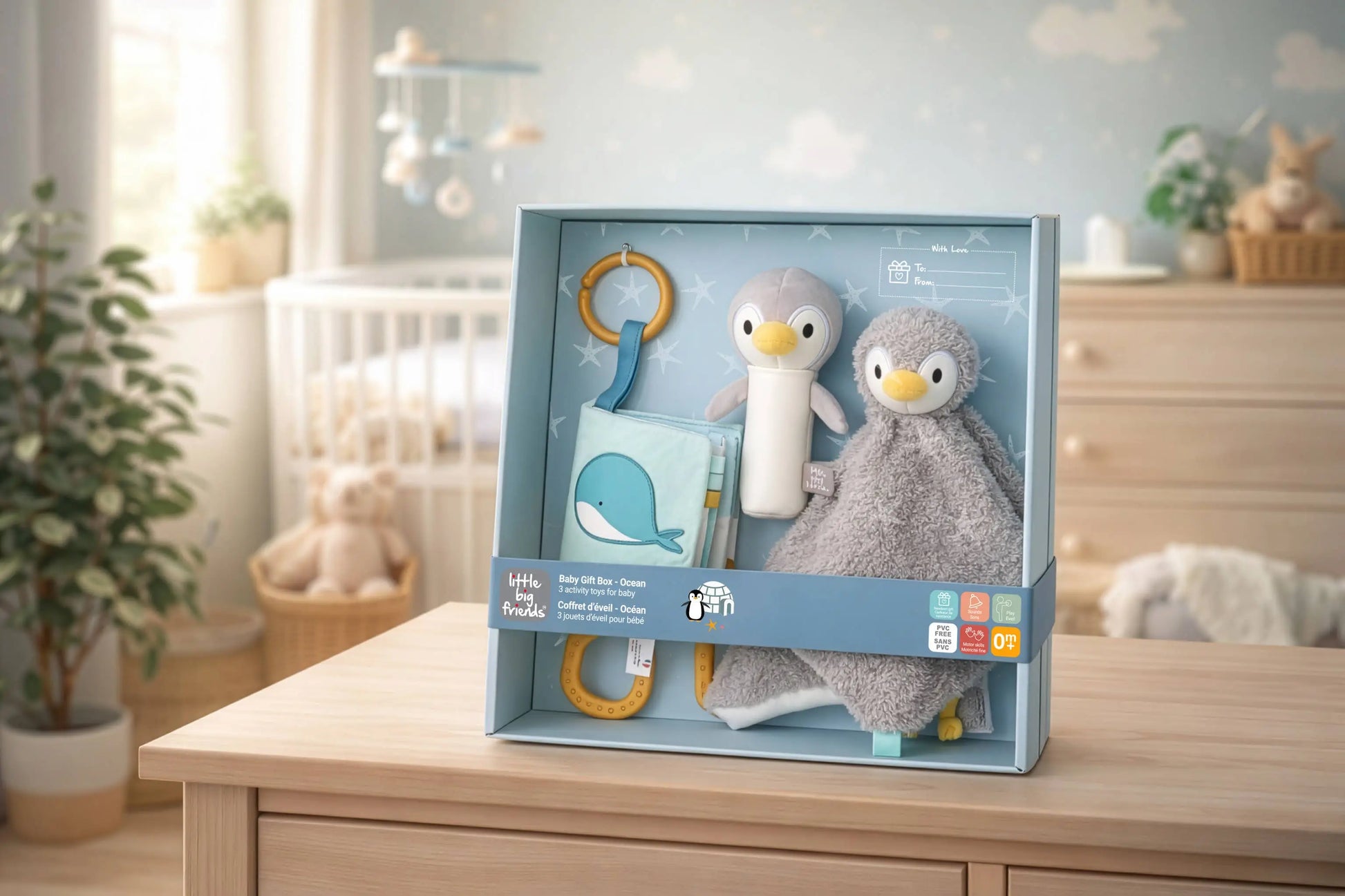 Baby toy set in packaging on a wooden surface with a nursery background