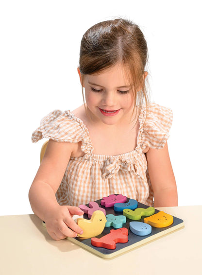 Child playing with a colourful wooden puzzle on a white background