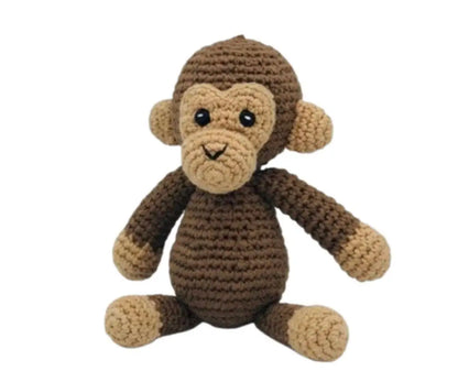A crocheted plush monkey toy in shades of brown and beige, featuring black bead eyes and a stitched smile, set against a plain white background.