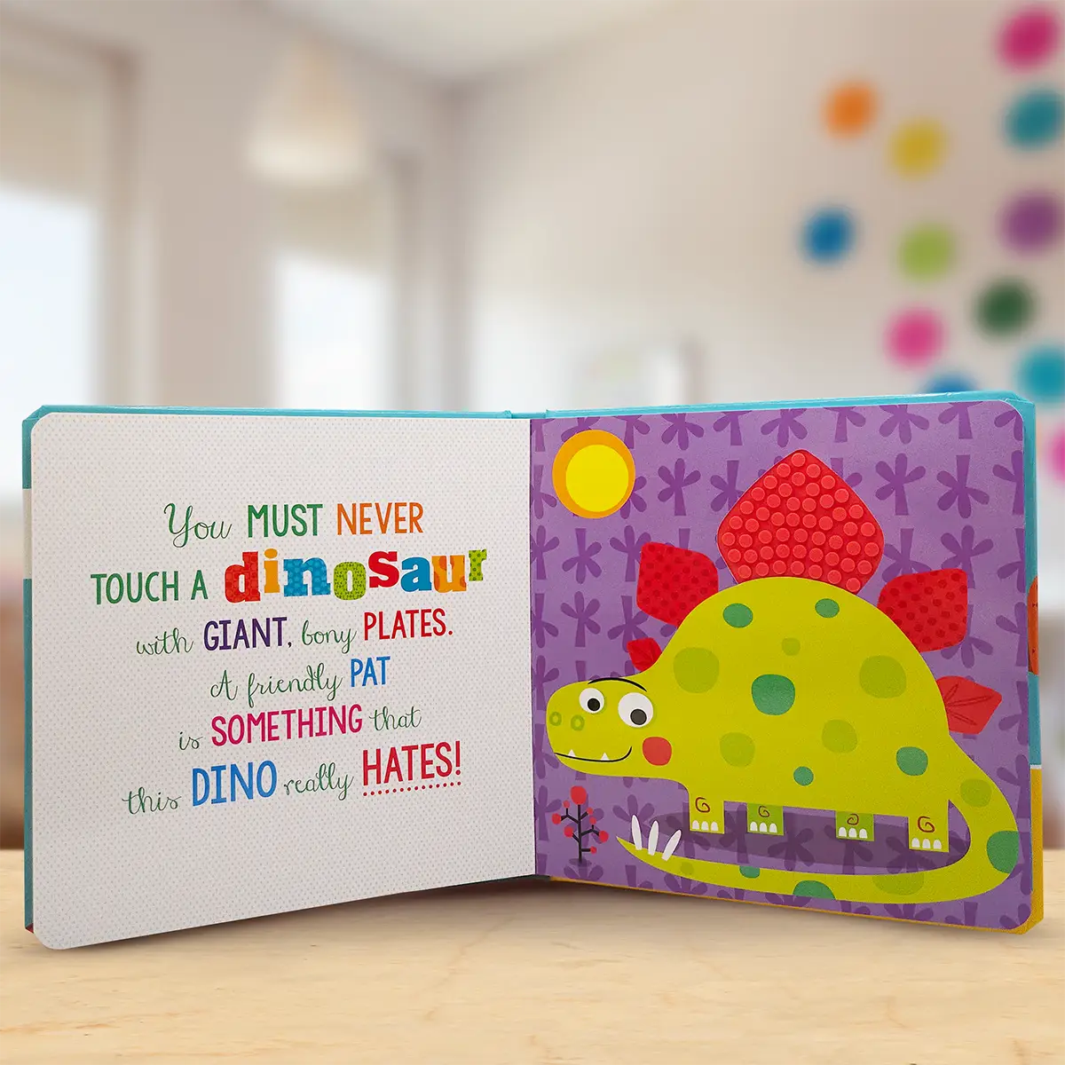 Children's book open to a page with a dinosaur illustration and text on a wooden surface.