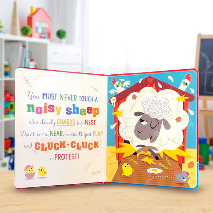An open children's board book with colourful illustrations and text, showing a sheep in a barn with chicks and a mouse. The book is photographed on a light wooden surface with a blurred playroom background.