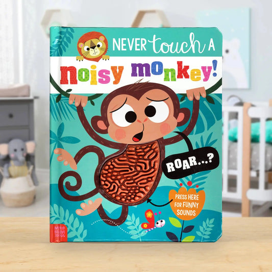 A children's board book titled 'Never touch a noisy monkey!' standing upright on a wooden surface in a nursery setting. The cover features a cartoon monkey with a textured, sound-making body and colourful playful text.