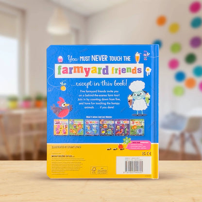 The back cover of a children's book titled 'You MUST NEVER TOUCH the farmyard friends' stands upright on a light wooden table. The cover is predominantly bright blue with a yellow band at the bottom and colorful illustrations of farmyard characters and small book covers.