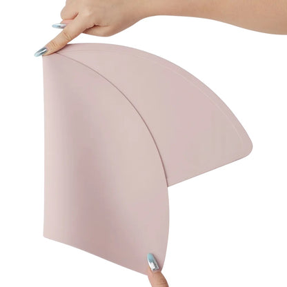 Close-up of soft, flexible silicone placemat in dusty pink, dusty blue, and pale grey.