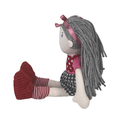 Stuffed doll with grey hair, pink bow, red shoes, and checkered skirt on a white background