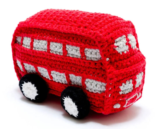 A crocheted toy double-decker bus in red and white with black wheels, photographed on a plain white background.