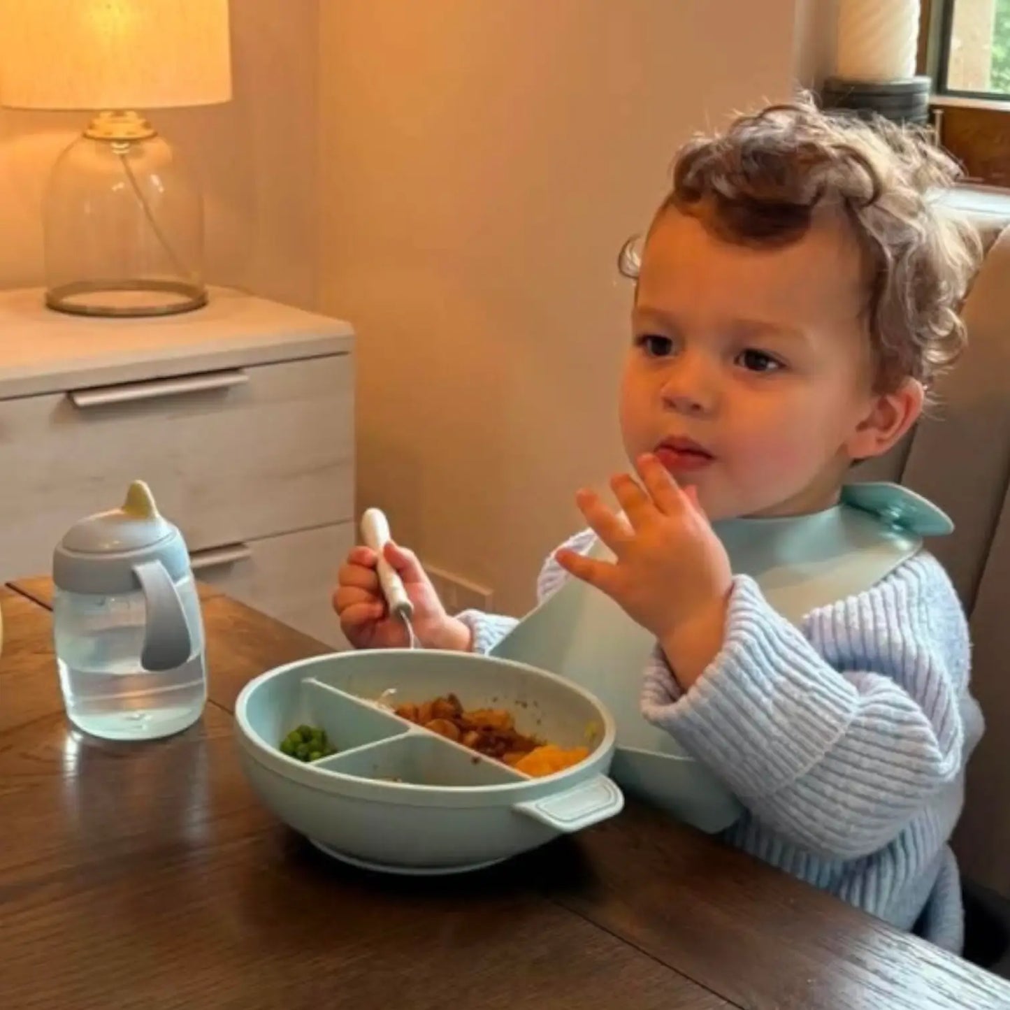 Toddler eating from blue silicone bowl