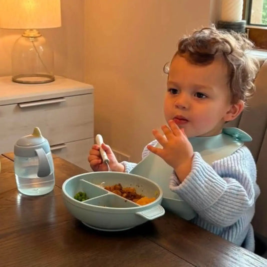 Toddler eating from blue silicone bowl