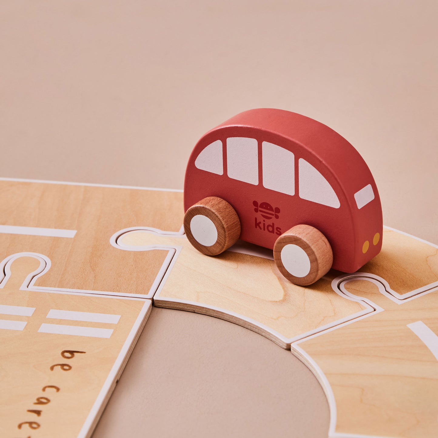 Red wooden toy car on a wooden road